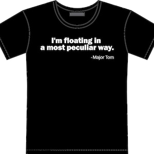 May include: Black t-shirt with the quote "I'm floating in a most peculiar way." attributed to Major Tom in white text. The shirt has a crew neck and short sleeves. The design is centered on the front of the shirt.