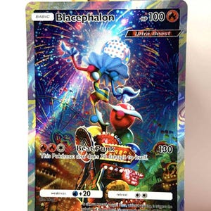 May include: A holographic Blacephalon Pokémon trading card. The card features a colorful illustration of a creature with a blue frilly head, red face, and striped limbs. Text includes "Blacephalon", "Ultra Beast", and "Beat Punk".