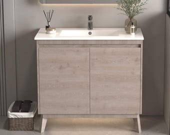 May include: A light wood bathroom vanity with a white porcelain sink and two cabinet doors. The vanity has a modern design with sleek lines and a minimalist aesthetic.