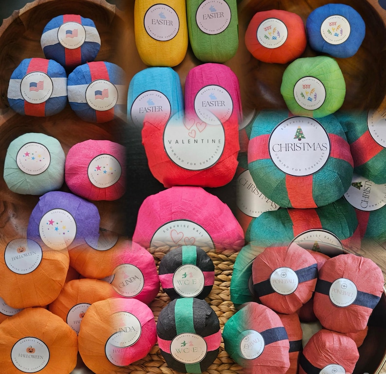 May include: A collection of round surprise balls wrapped in colorful crepe paper, each featuring a circular label with themed text and graphics including Easter, Valentine, Christmas, and Halloween designs, arranged in a group.