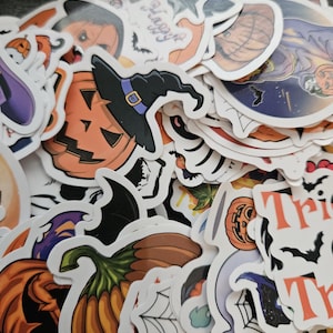 May include: A collection of assorted Halloween-themed stickers featuring orange pumpkins, jack-o'-lanterns with black witch hats, spider webs, bats, and text including "Happy" and "Trick". The stickers have white borders and various illustrations.