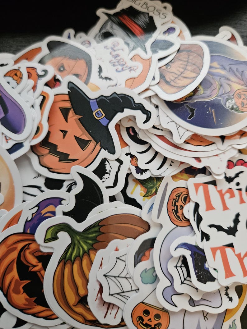 May include: A collection of assorted Halloween-themed stickers featuring orange pumpkins, jack-o'-lanterns with black witch hats, spider webs, bats, and text including "Happy" and "Trick". The stickers have white borders and various illustrations.