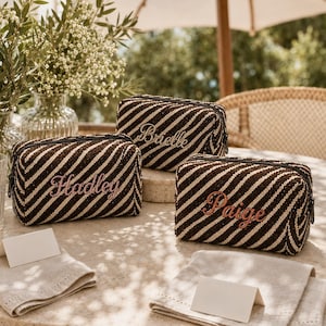 K&ouml;nnte beinhalten: Drei rechteckige Rei&szlig;verschlusstaschen mit einem diagonalen Streifenmuster in Dunkelbraun und Creme. Jede Tasche ist mit einem Namen in Schreibschrift bestickt: Brielle, Hadley und Paige. Die Taschen haben eine strukturierte Weboptik.