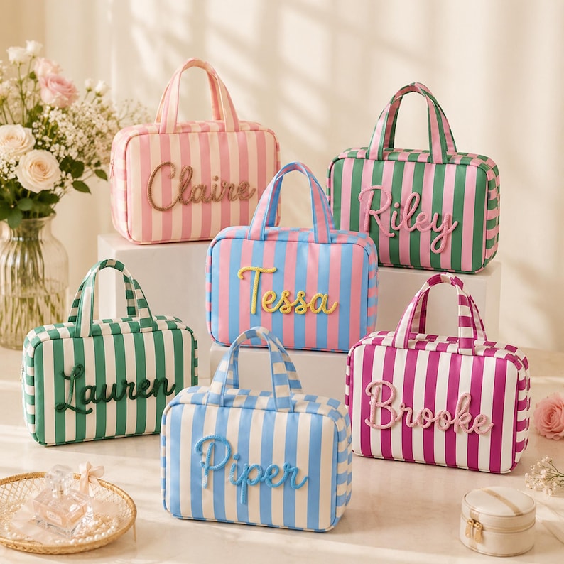 May include: A collection of six rectangular striped cosmetic bags with top handles, each featuring a unique name in raised script lettering: Claire, Riley, Tessa, Lauren, Piper, and Brooke. The bags come in various color combinations including pink, green, blue, and purple stripes.