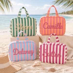 May include: Four rectangular zippered travel bags with top handles, each featuring vertical stripes and a name embroidered in cursive script on the front. The bags are colored in green and white, orange and pink, blue and pink, and magenta and white.