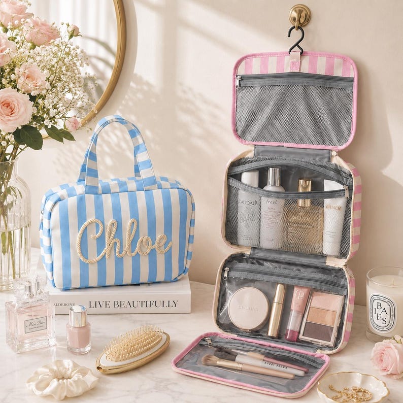 May include: A blue and white striped toiletry bag with the name Chloe embroidered on the front, alongside a matching pink and white striped hanging travel organizer filled with various skincare bottles, makeup compacts, and cosmetic brushes.