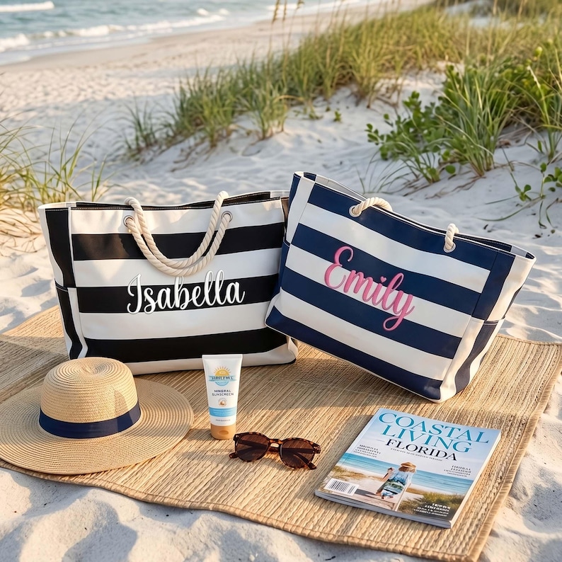 May include: Two large tote bags with horizontal stripes, one black and white with the name Isabella, the other navy and white with the name Emily. Includes a straw hat with a navy band, a tube of sunscreen, sunglasses, and a Coastal Living magazine.