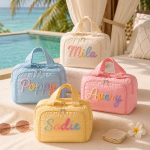 Puede incluir: Cuatro neceseres rectangulares acolchados en color crema, azul claro, rosa y amarillo. Cada bolsa cuenta con un asa superior, un bolsillo frontal con cremallera y un nombre bordado en hilo multicolor: Mila, Poppy, Avery y Sadie.