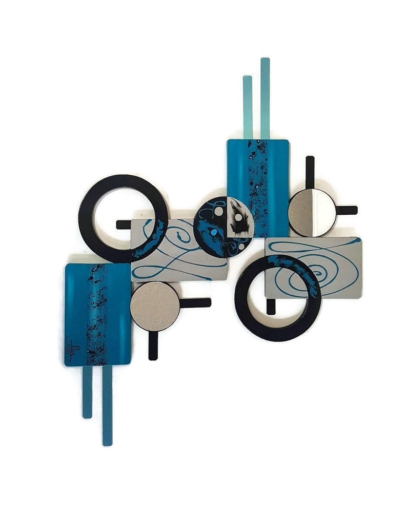 May include: Abstract wall art featuring geometric shapes in shades of blue, black, and silver. The piece includes circles, squares, and rectangles, with a swirling pattern on some of the shapes.