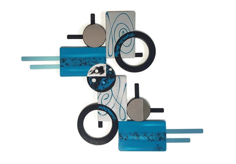 May include: Abstract wall art sculpture with geometric shapes in shades of blue, black, silver, and white. The sculpture features circles, squares, and rectangles.