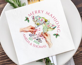 May include: White square paper napkin with a watercolour illustration of two martini glasses filled with olives and Mahjong tiles. The text "MERRY MAHJONG" and "AMELIA & THOMAS EST. 2025" are printed in pink.