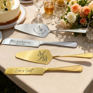 May include: Four wedding cake serving utensils on a table. Two silver utensils are engraved with "AMELIA & MASON" and "THE ANDERSONS 09.13.2026". Two gold utensils are engraved with "A AMELIA & MASON M" and "Love is Sweet".