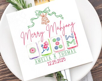 May include: White square paper napkin with a watercolor design. The napkin features the text "Merry Mahjong" in pink, with four Mahjong tiles and the names "Amelia & Thomas" and the date "12.25.2025" in green.