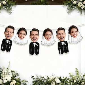 May include: A decorative banner featuring smiling faces of a bride and groom. The groom is wearing a black tuxedo with a bow tie, and the bride is wearing a white veil. The banner is strung on a white string, perfect for a wedding.