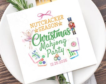 May include: A white square napkin with the text "Nutcracker Season Christmas Mahjong Party" in orange and green. The napkin features illustrations of a ballerina, nutcracker, and mahjong tiles. The date 12.25.2025 is printed in pink.