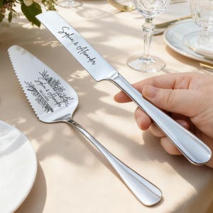 May include: A silver cake knife and server set. The knife and server are engraved with the names "Sophia & Alexander" and the date "08.12.2026". The server has a floral design.