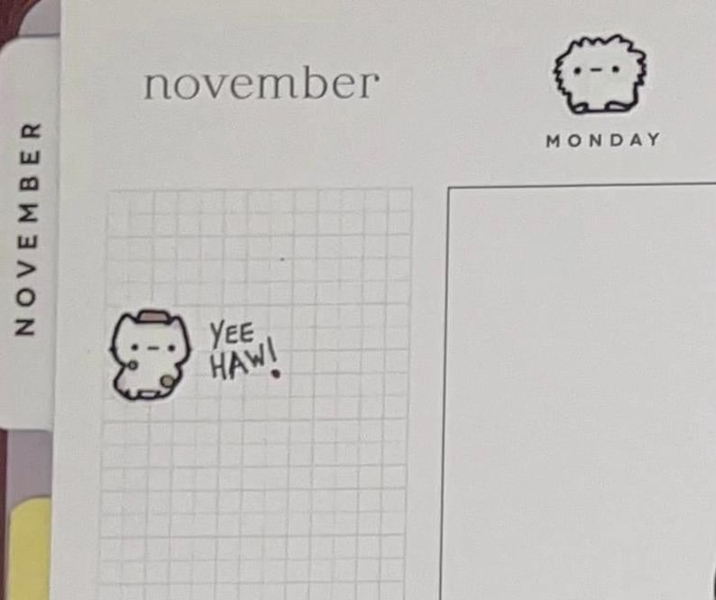 Puede incluir: Una p&aacute;gina de planificador con la palabra "noviembre" en la parte superior. Una pegatina de un animal de dibujos animados con un sombrero de vaquero con las palabras "Yee Haw!" est&aacute; en la cuadr&iacute;cula. Un peque&ntilde;o animal de dibujos animados est&aacute; en la esquina superior derecha con la palabra "lunes" debajo.