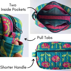 May include: A teal quilted travel bag with a floral print and black zipper. The bag has two inside pockets, pull tabs, and a shorter handle.