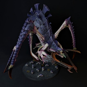 May include: A detailed, painted miniature of a Tyranid Hive Tyrant, a monstrous alien creature with a bio-mechanical body, multiple limbs, and a large, sharp mouth. The miniature is painted in shades of purple, white, and gold.