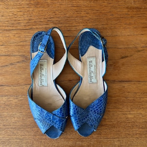 以下が含まれることがあります： クロスストラップのデザインが施された、青い革のヒールサンダルです。ウィルキス・バッシュフォード製で、イタリア製です。