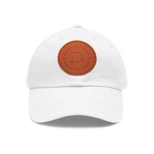 May include: White baseball cap with a curved brim. A circular brown patch on the front features the text "Return with Honor" around a gray curved arrow.