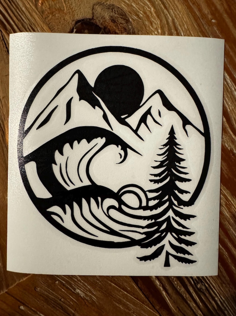 May include: Black and white sticker design featuring a mountain range, a wave, a pine tree, and a sun. The design is enclosed in a circle.