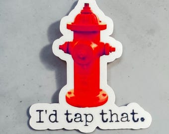 Könnte beinhalten: Ein Aufkleber mit einem leuchtend roten Hydranten und dem Text "I'd tap that". Der Hydrant hat ein klassisches Design mit abgerundeter Oberseite und mehreren Ausgängen, vor weißem Hintergrund.