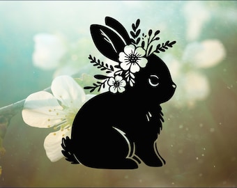 May include: A black silhouette of a rabbit with a floral crown. The rabbit is sitting on a light green background with white flowers.