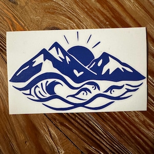 May include: Blue silhouette sticker of mountains, a sun, and waves with a heart in the center.