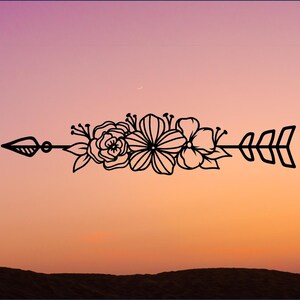 May include: A black floral arrow design with a simple arrow shape and flowers in a line. The arrow is pointing to the right. The background is a gradient of pink and orange.