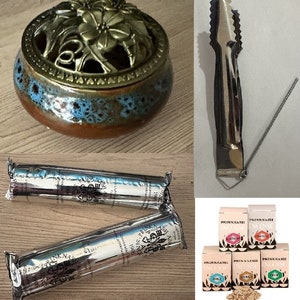 May include: A ceramic incense burner with a floral design and a metal lid. The burner is brown with blue and white accents. The set includes two incense sticks, a metal incense stick holder, and six small bags of incense. The incense bags are labelled "Prinknash Incense" and come in a variety of scents.