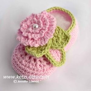 Puede incluir: Zapatillas de bebé de ganchillo rosa con una flor de ganchillo verde y una perla. www.ketzl.etsy.com ©Jennifer Lownds