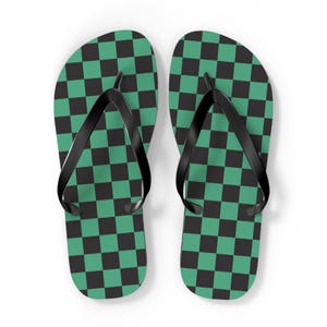May include: A pair of flip-flops with a green and black checkered pattern. The straps are black. The sandals are designed for casual wear and are suitable for the beach or everyday use.