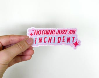 May include: Pink and white sticker with glitter and the text "Nothing just an incident" in red.