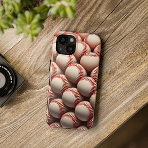May include: A white and red baseball phone case with a close-up image of baseballs.