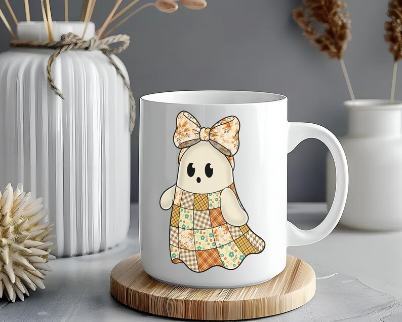 Pode incluir: Caneca de cer&acirc;mica branca com um personagem de desenho animado fantasma com um vestido de retalhos e um la&ccedil;o. O fantasma tem uma express&atilde;o amig&aacute;vel. A caneca est&aacute; em uma base de madeira.