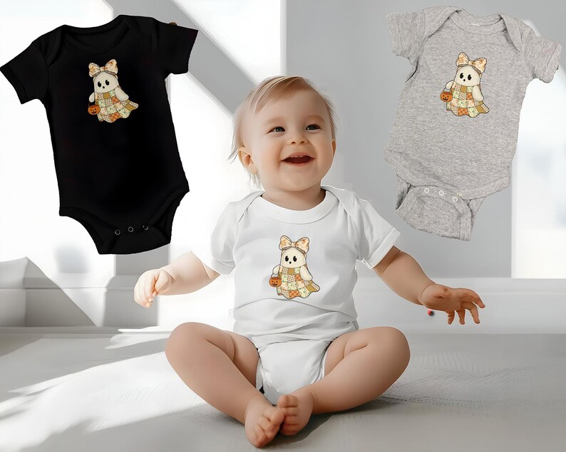 Pode incluir: Tr&ecirc;s bodies de beb&eacute; em preto, branco e cinzento. Cada body apresenta um desenho de fantasma de desenho animado com um la&ccedil;o, um vestido de patchwork e uma ab&oacute;bora. O beb&eacute; na imagem est&aacute; a usar um body branco com o mesmo desenho de fantasma.