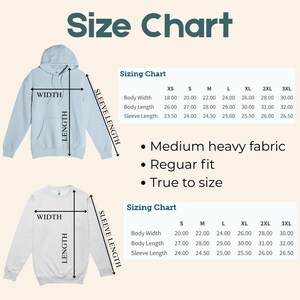 May include: A size chart graphic with a light blue hoodie and a light gray sweatshirt, both with measurement labels. The chart includes body width, body length, and sleeve length measurements in inches for sizes XS to 3XL. Text states "Medium heavy fabric", "Regular fit", and "True to size".