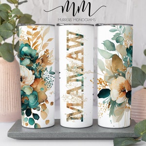 May include: Three white stainless steel tumblers with a floral design in shades of teal, gold, and brown. The tumblers have a gold glitter design with the name "MATTHEW" on the middle tumbler.