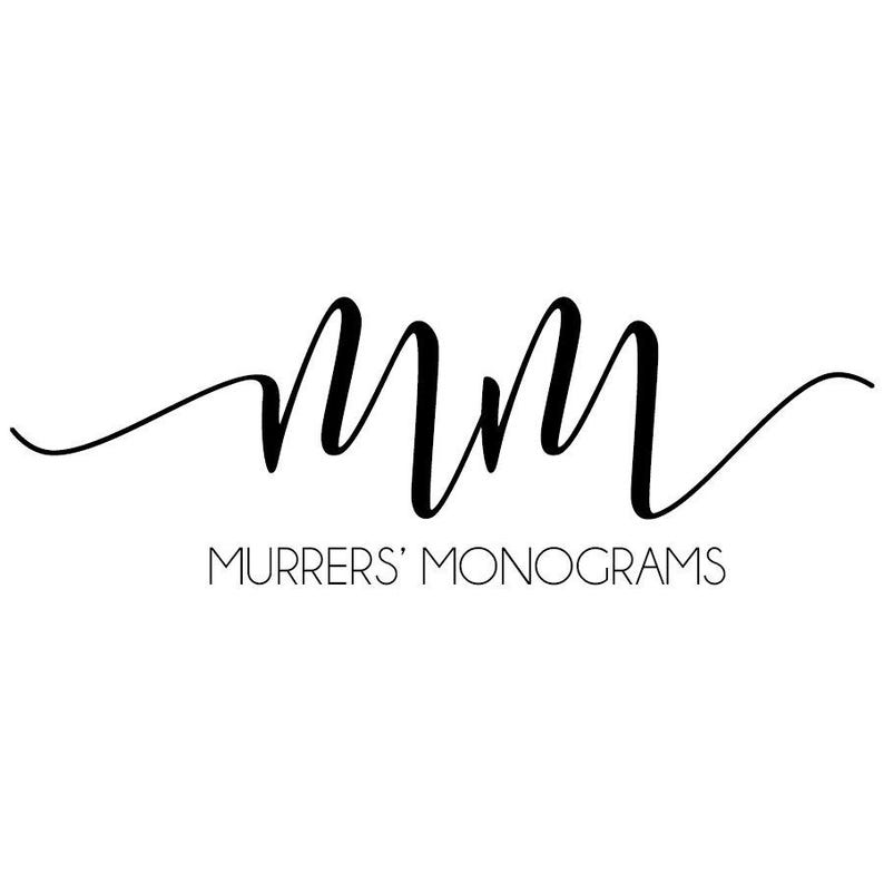 May include: A black and white logo with the letters "MM" in a cursive font. The text "Murrer's Monograms" is below the letters.