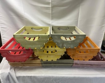 May include: A set of six wooden crates in various colors, including red, yellow, orange, and gray. The crates are stacked on top of each other and have a rustic, farmhouse style.