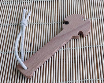 May include: A wooden tool with a handle and a unique shape at the end, resembling a hammer or a wrench. The tool is tied with a white string.