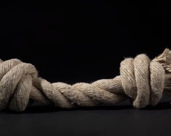 May include: A thick, knotted rope dog toy made of natural fibers. The rope is beige and has a frayed texture.