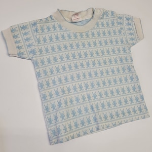 May include: A white baby t-shirt with a blue bunny pattern. The shirt has a round neckline and short sleeves.