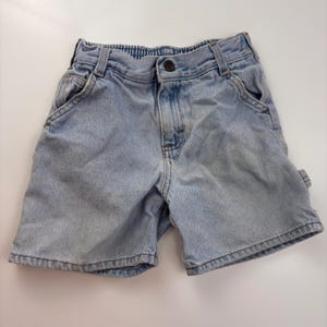 Puede incluir: Pantalones cortos de mezclilla azul claro con cierre de bot&oacute;n y dos bolsillos delanteros. Los pantalones cortos tienen un corte holgado y est&aacute;n hechos de una tela suave y c&oacute;moda.