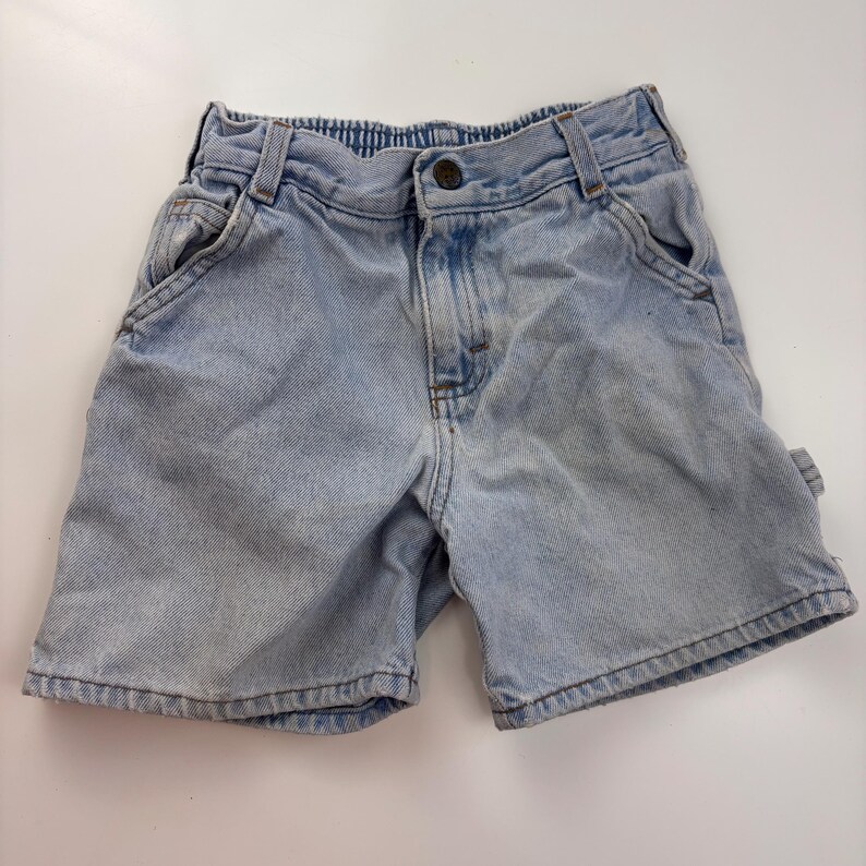 Puede incluir: Pantalones cortos de mezclilla azul claro con cierre de bot&oacute;n y dos bolsillos delanteros. Los pantalones cortos tienen un corte holgado y est&aacute;n hechos de una tela suave y c&oacute;moda.