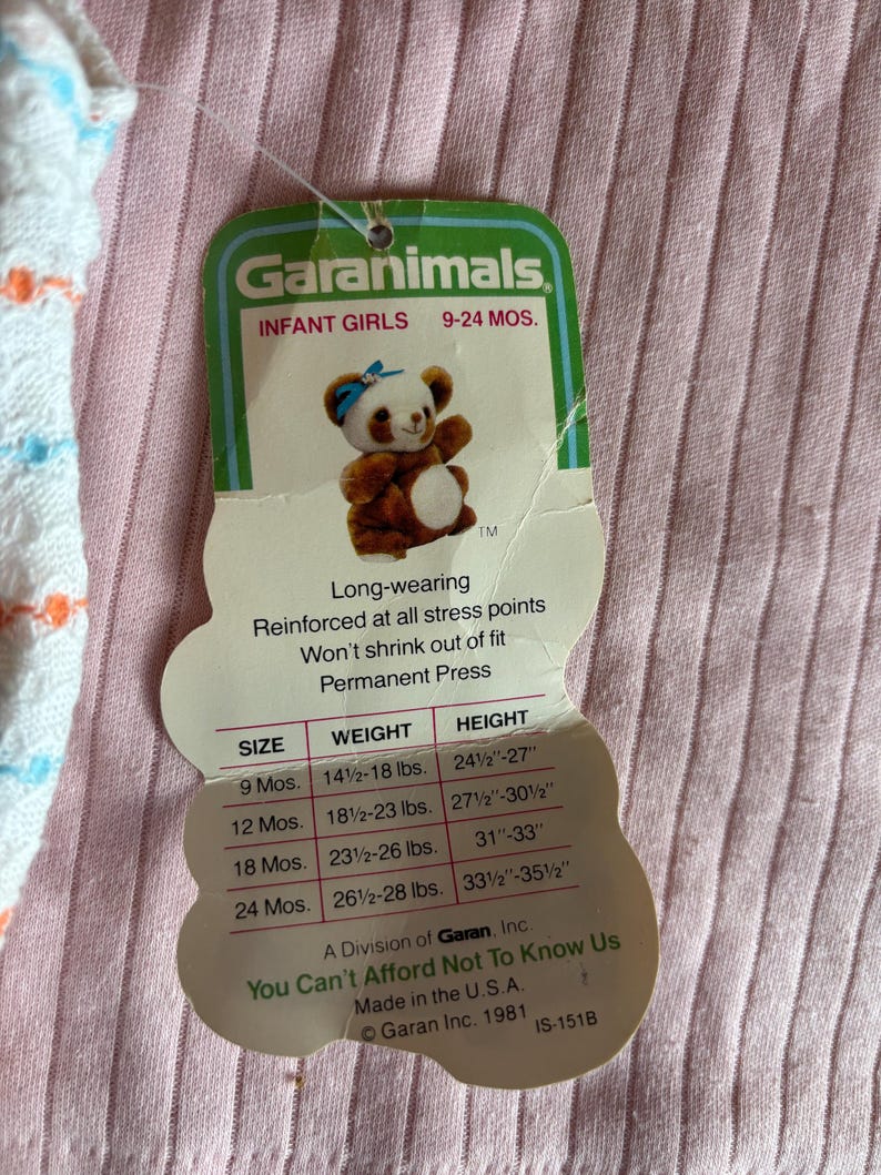 K&ouml;nnte beinhalten: Ein Garanimals-Etikett f&uuml;r Babykleidung f&uuml;r M&auml;dchen mit einem Cartoon-Panda mit einer blauen Schleife. Das Etikett enth&auml;lt Gr&ouml;&szlig;en-, Gewichts- und H&ouml;henangaben f&uuml;r Babys im Alter von 9-24 Monaten. Auf dem Etikett steht auch "You Can't Afford Not To Know Us."