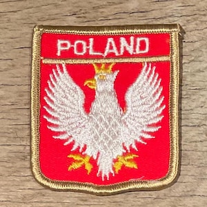 May include: Embroidered patch featuring the Polish coat of arms, a white eagle with a golden crown, beak, and talons, set against a red background. The word "POLAND" is embroidered in white at the top. The patch has a gold border.