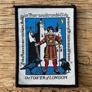 Op de afbeelding: Geborduurde patch met een Beefeater in rood en goud uniform, voor de Tower of London. De patch bevat de tekst: "Als de raven zouden vertrekken, zou de White Tower afbrokkelen & de macht van Groot-Brittannië afnemen."