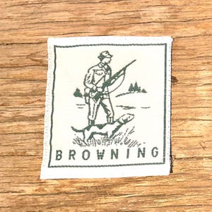 May include: A white ceramic mug with a black handle and the text "But First, Coffee" in a bold, black font. The mug is set against a blurred background, suggesting a cozy setting.